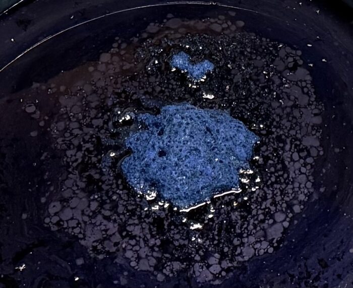 発酵して染められる状態となっている藍染の染料。液に浮かんでいる藍の華は顔料としても使用できる